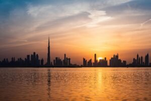 Enchanting view of Dubai's skyscrapers at sunset with the iconic Burj Khalifa outlined against the vivid sky.